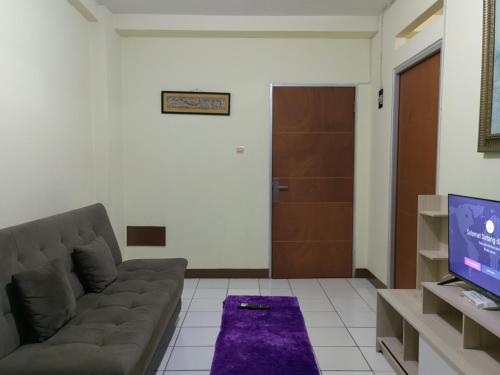 a living room with a couch and a television at Cibubur Village By Arsakha Property Management in Cibubur