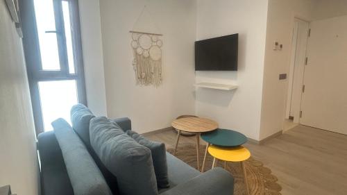 a living room with a blue couch and a table at Selecta Marbella Sentire Apartaments in Marbella