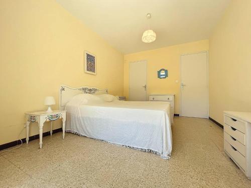 - une chambre avec un lit blanc, une table et une porte dans l'établissement Appartement T2 avec Terrasse - Accès Direct Plage des Lecques, Parking, Équipé pour 2-4 Personnes - FR-1-770-8, à Saint-Cyr-sur-Mer