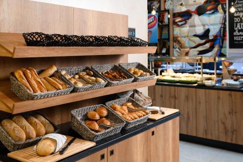 a bakery with baskets of bread and pastries on shelves at T62 Hotel in Budapest