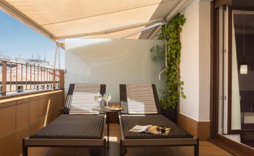 a balcony with two chairs and a table at Francisco I Boutique in Madrid