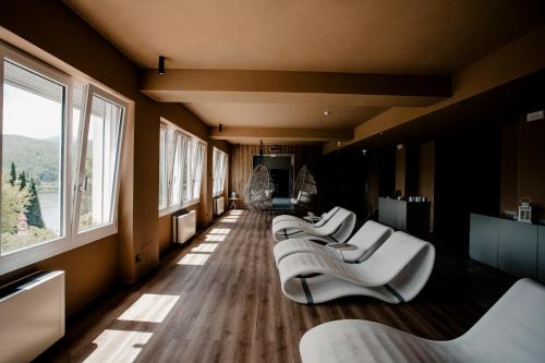 a row of white chairs in a room with windows at Hotel Del Lago Piediluco Active & SPA in Piediluco