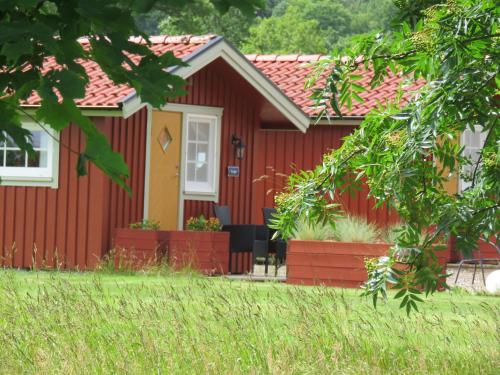 a red house with a yellow door and a yard at Karlsberg Gård B&B in Tvååker