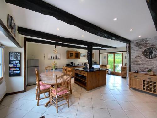 une cuisine et une salle à manger avec une table et des chaises dans l'établissement Gîte Le Chêne doré, à La Boussac