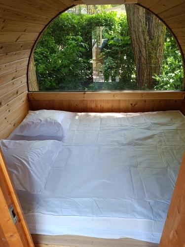 a bed in a tiny house with a window at Camping Le Douzou in Bouzic