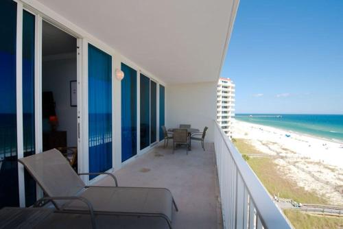 a balcony with chairs and a view of the beach at Lighthouse Condos Gulf Shores in Gulf Shores