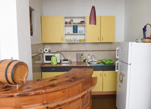 a kitchen with yellow cabinets and a white refrigerator at Guesthouse Ema in Banja Luka