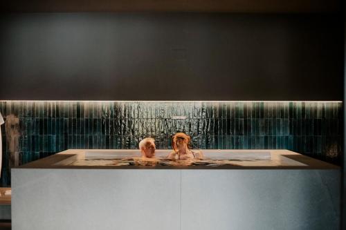 two people in a bath tub with a waterfall at Hotel Del Lago Piediluco Active & SPA in Piediluco