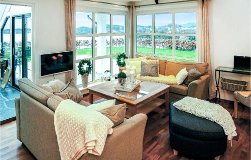 a living room with two couches and a tv at Nice Home In Lundegrend With Wifi in Grimsland