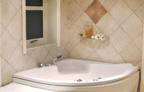 a white tub in a bathroom with a window at Nice Home In Lundegrend With Wifi in Grimsland