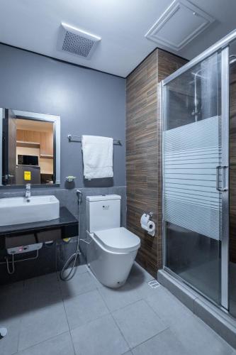 a bathroom with a toilet and a sink and a shower at The Radiance Manila Bay in Manila