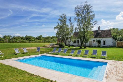 une piscine avec des chaises et une maison dans l'établissement So Villa La Repreneliere 45 - Heated pool - Soccer - 2h from Paris - 30 beds, à Viglain