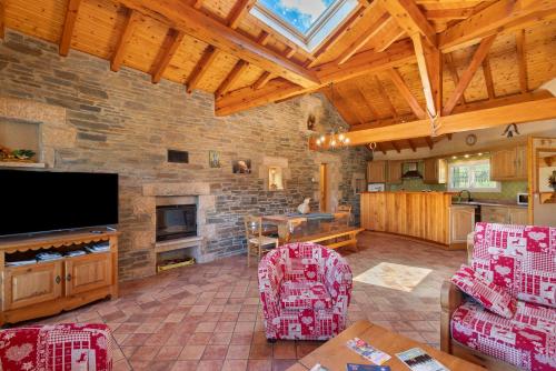 un grand salon avec un mur en pierre dans l'établissement Le Calmadou, à Formiguères