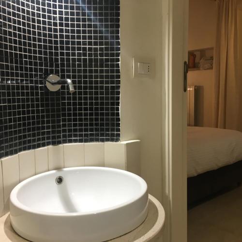 a bath tub in a bathroom with a black tiled wall at Apartments Bedlecce in Lecce