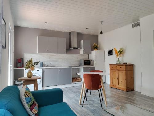 une cuisine et un salon avec un canapé et une table dans l'établissement Les Papillons, à Perpignan