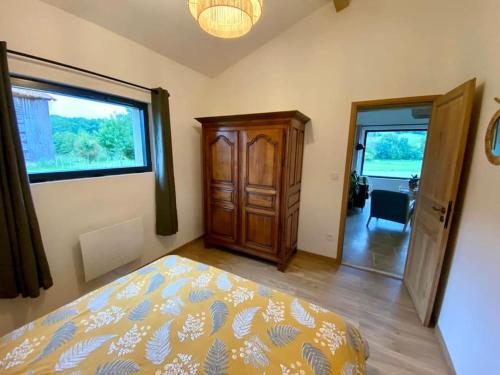 a bedroom with a bed and a large window at Maison de charme à la campagne in Montpezat