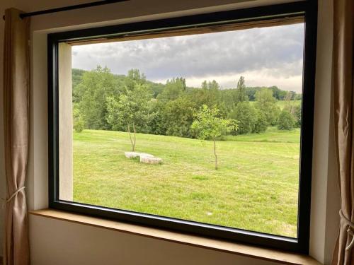 a window with a view of a field of grass at Maison de charme à la campagne in Montpezat