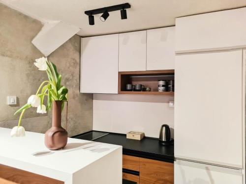 a kitchen with white cabinets and a vase with flowers at Step to Kotor bay Perast in Perast