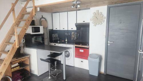 une cuisine avec un comptoir noir et une échelle dans l'établissement Vista Matémala - Appartement avec Vue Lac et Montagne, aux Angles