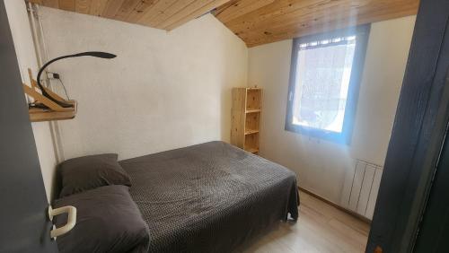 une petite chambre avec un lit et une fenêtre dans l'établissement Vista Matémala - Appartement avec Vue Lac et Montagne, aux Angles