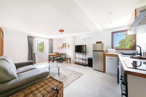un salon avec un canapé et une cuisine dans l'établissement Coeur de Var - appt climatisé, à Pontevès