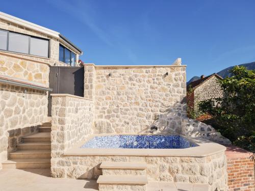 a stone house with a plunge pool in front at Step to Kotor bay Perast in Perast