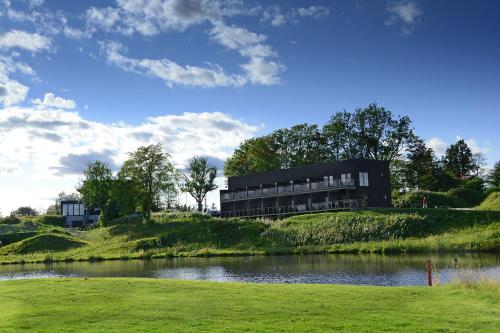 a building on top of a hill next to a lake at Sand Golf Club in Bankeryd