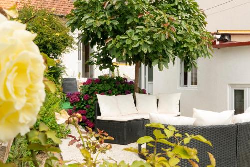 a patio with white chairs and flowers at Growth House in Porto