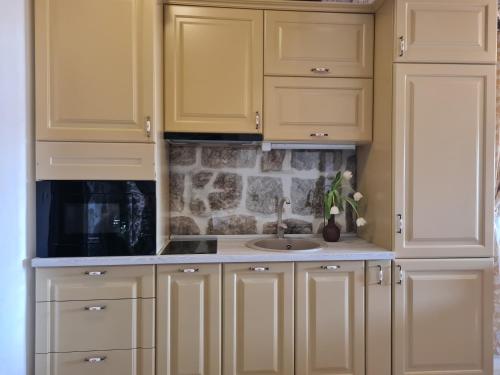 a kitchen with yellow cabinets and a sink at Step to Kotor bay Perast in Perast