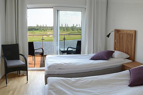 a bedroom with two beds and a balcony with a view at Sand Golf Club in Bankeryd