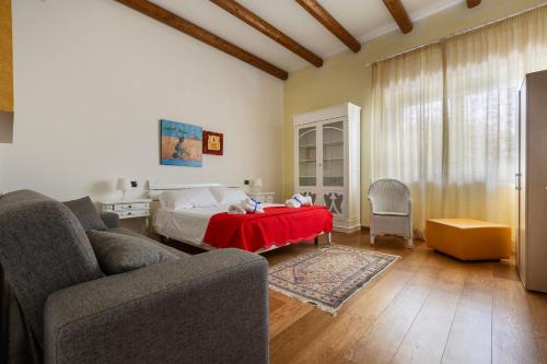 a living room with a bed and a red table at Villa Miramare by Perle di Puglia in Torre Suda