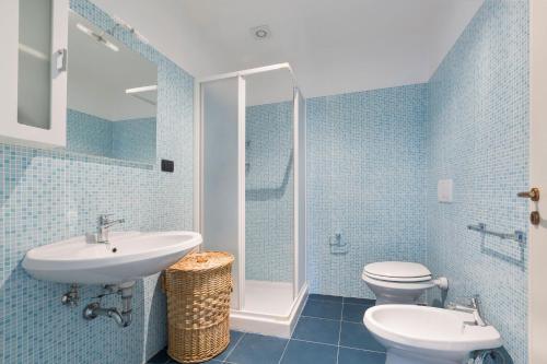 a blue bathroom with a sink and a toilet at Villa Miramare by Perle di Puglia in Torre Suda