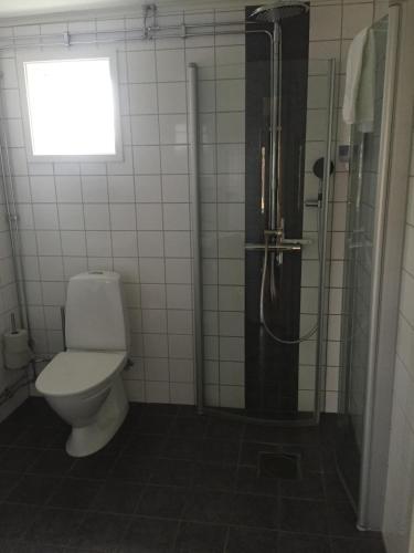 a bathroom with a toilet and a shower with a window at Sand Golf Club in Bankeryd