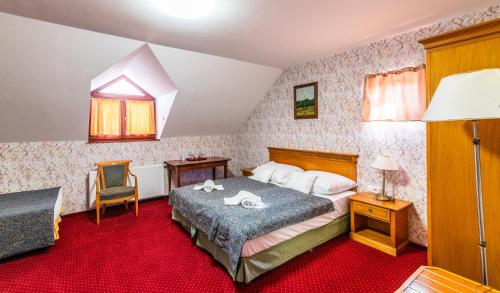 a bedroom with a bed and a chair at Borhotel Sziluett Farkasmály in Gyöngyös