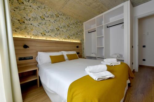 a bedroom with a large white bed with yellow sheets at ELS 4 PICS in Puigcerdà