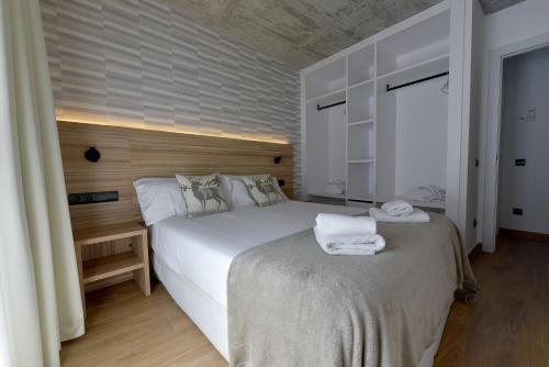 a bedroom with a bed with towels on it at ELS 4 PICS in Puigcerdà