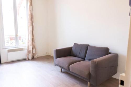 un canapé dans un salon avec une fenêtre dans l'établissement calm retreat near Montrouge, à Villejuif
