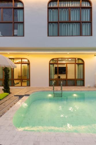 a swimming pool in front of a building at Esther Villa Khaoyai in Ban Bung Toei