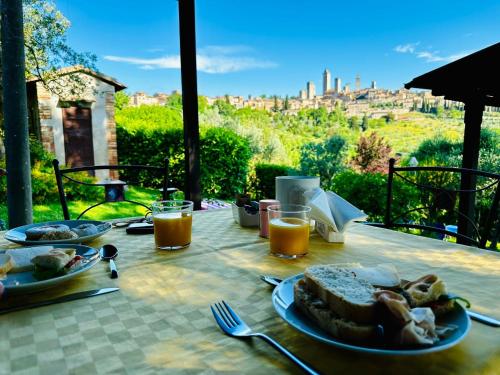 une table avec une assiette de nourriture et du jus d'orange dans l'établissement Antico Casolare, à San Gimignano
