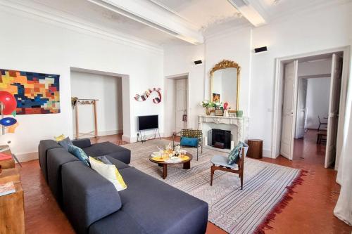 un salon avec un canapé bleu et une cheminée dans l'établissement Le Palais 10, Superbe appartement d'Exception Authentique Centre Historique, à Sète