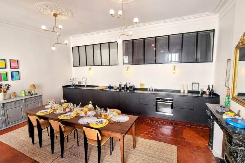 - une cuisine avec une table à manger et des chaises dans l'établissement Le Palais 10, Superbe appartement d'Exception Authentique Centre Historique, à Sète