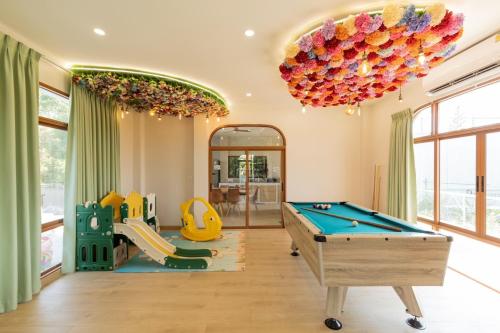 a living room with a pool table and a chandelier at Esther Villa Khaoyai in Ban Bung Toei