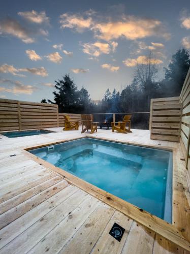 a swimming pool on a wooden deck with a wooden deck at ÈST Éco-cabines in Nouvelle
