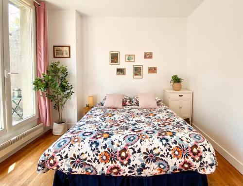 une chambre avec un lit avec une couette fleurie dans l'établissement Superbe studio en hypercentre, à Tours