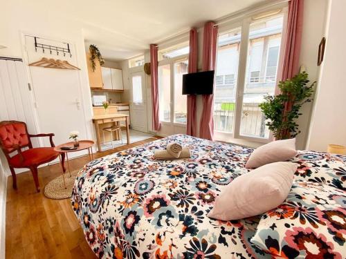 une chambre avec un grand lit avec un couvre-lit fleuri dans l'établissement Superbe studio en hypercentre, à Tours