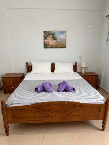 a bedroom with a bed with purple pillows on it at Vila Rapo in Himare
