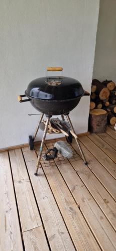 a black grill sitting on a stand on a wooden floor at Relaxing place on Godøya in Godøy