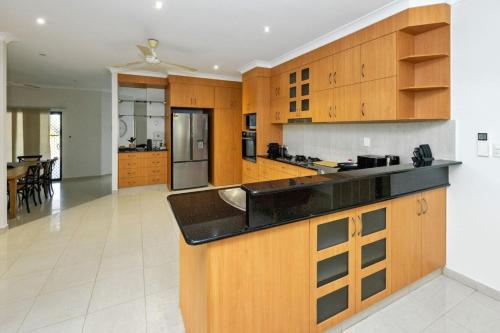 a large kitchen with wooden cabinets and a counter top at Bayview Beauty - Four Bedroom in Stuart Park