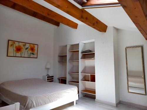 une chambre avec un lit et un miroir dans l'établissement Duplex Port Hyères Plage Vue Hippodrome, à Hyères