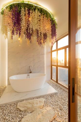 a bathroom with a white tub and a large window at Esther Villa Khaoyai in Ban Bung Toei